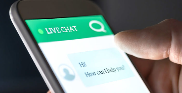 A phone shows a website live chat offering customer service.