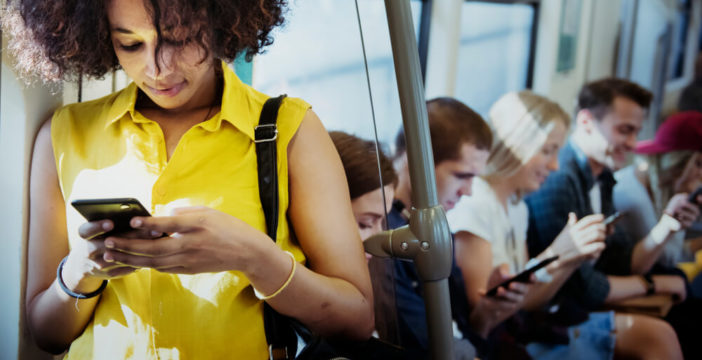 A woman uses her phone on public transportation.