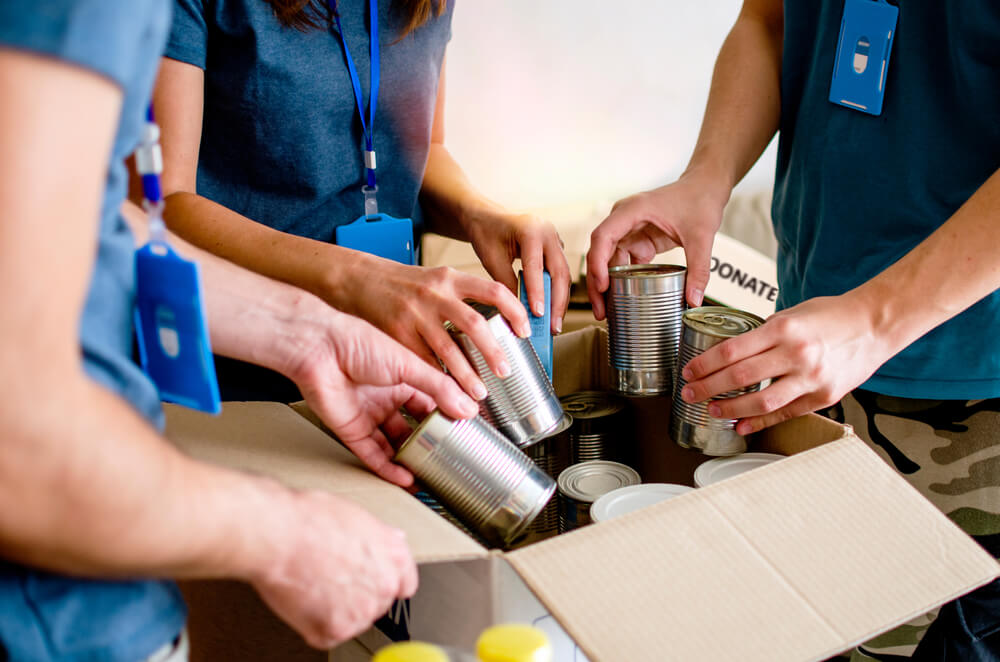 Volunteers support their local non-profit by spending time packing and organizing boxes.