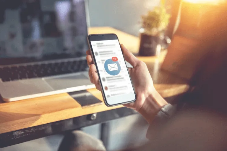 woman holding a phone with an email notification on the screen