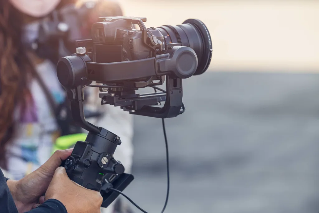 a man stands behind a film camera