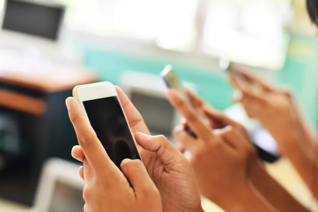 three people hold iPhones in their hands