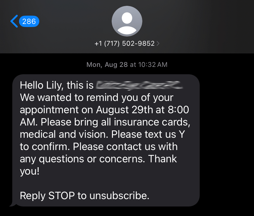 A screenshot of a text from a doctor reminding Lily of her upcoming appointment. The name of the business is blurred out.