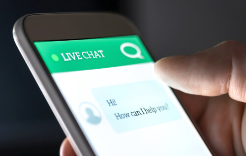 person holding a phone open to a live chat to show the advantages and disadvantages of online chat