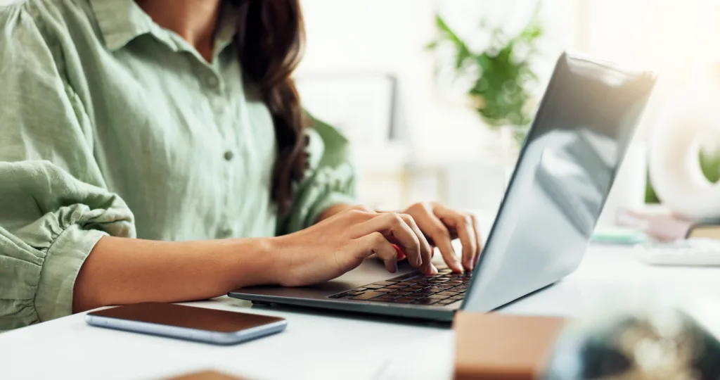 Digital marketing specialist working on a laptop at her desk.