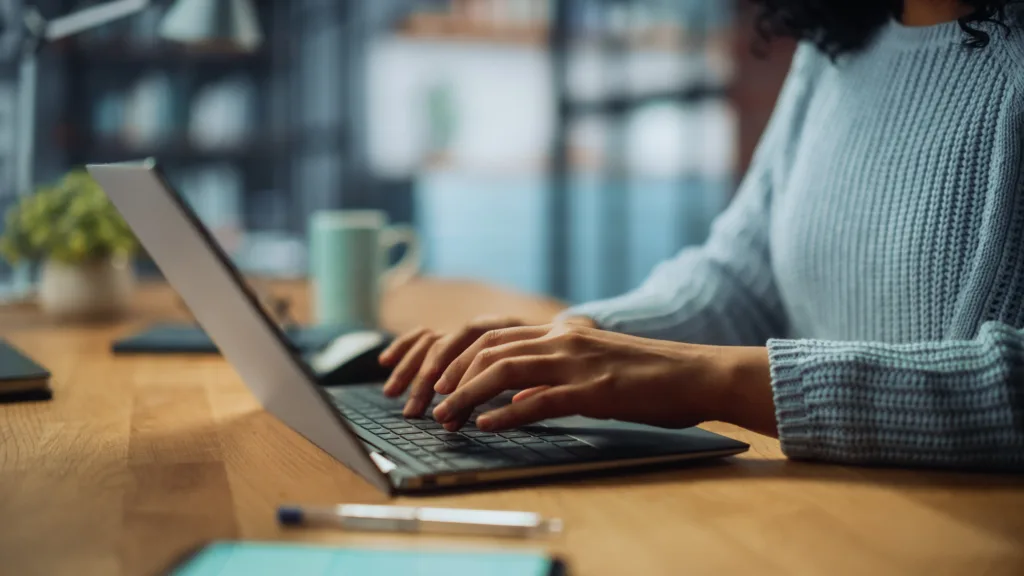 Digital marketing specialist working on a laptop at their desk.