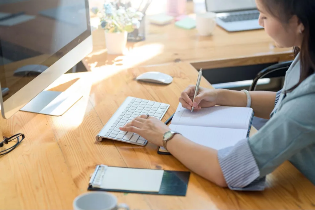 Marketer reviewing content cluster options to improve long-form content at her desk with Mac mouse and keyboard 