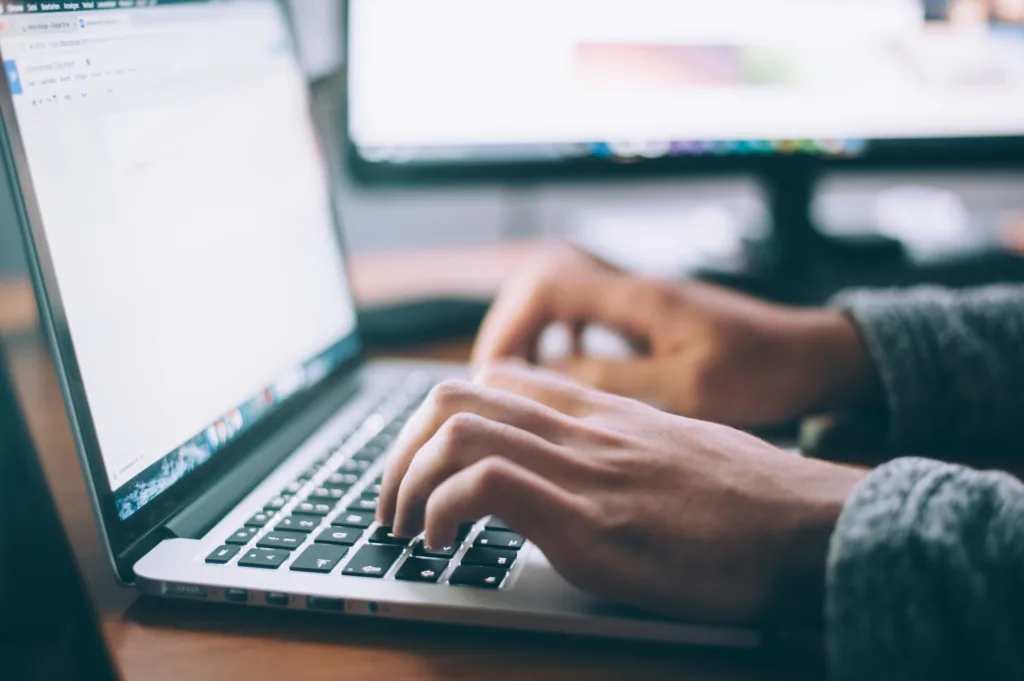Person typing on a laptop keyboard in Google Docs